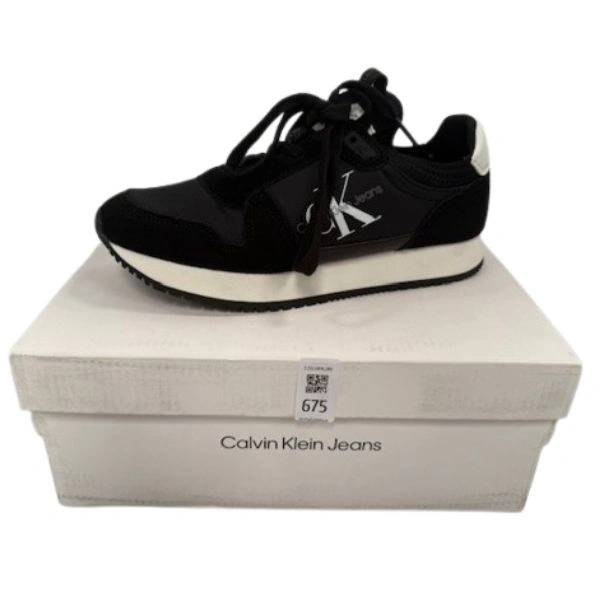Zapatilla Calvin Klein sin estrenar, presentada sobre una caja blanca, sin etiquetas visibles.