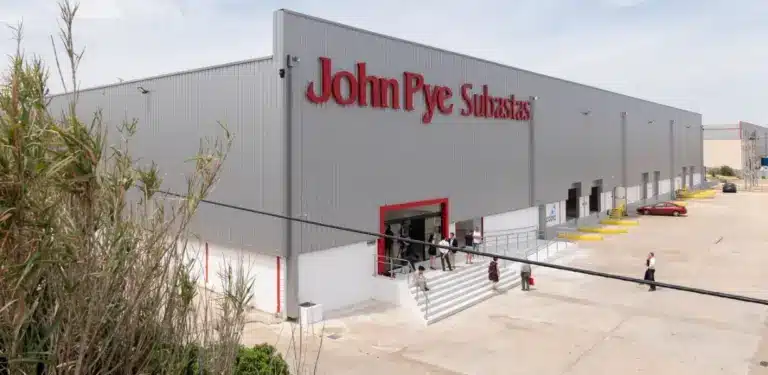 Compradores revisando lotes en una nave de subastas