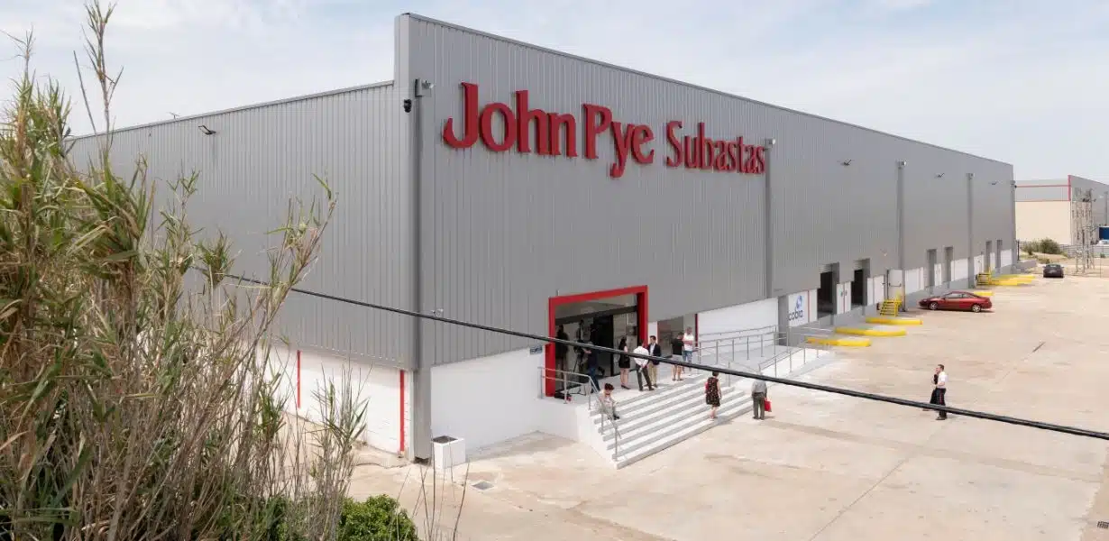 Compradores revisando lotes en una nave de subastas